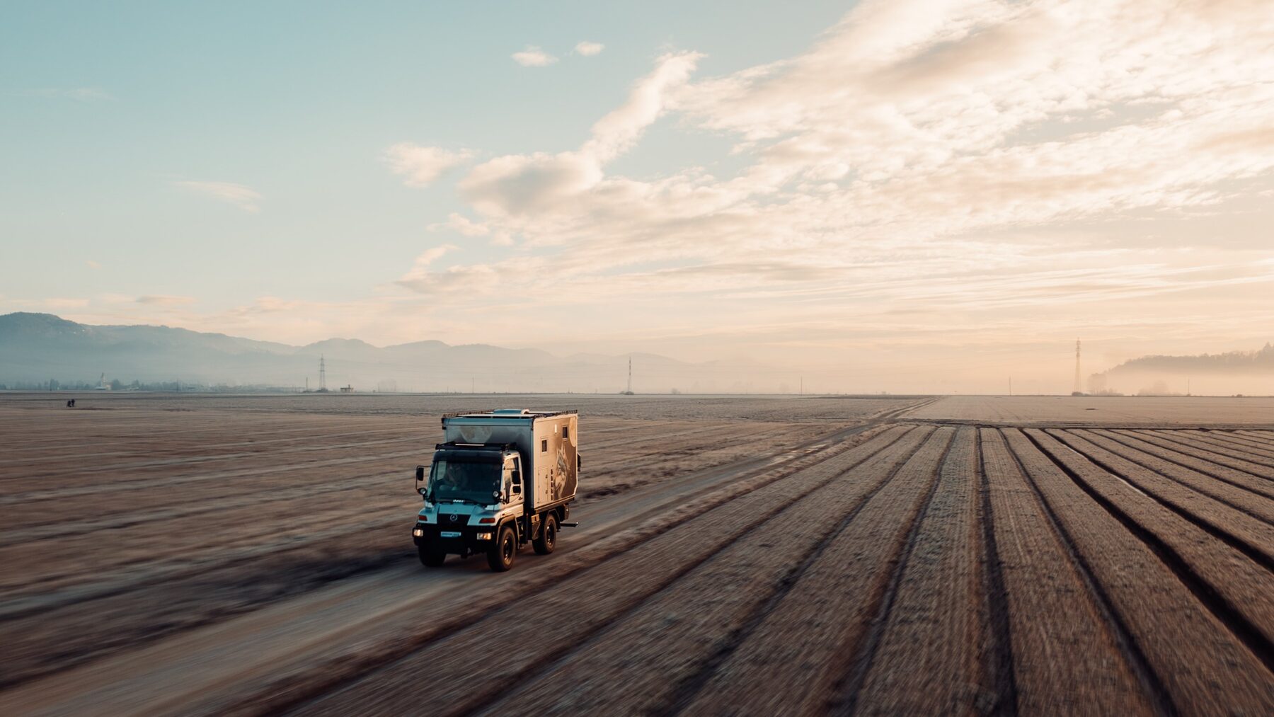 Custom expedition truck travelling across open fields